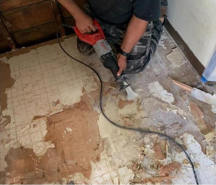 Our SERVPRO technician ripping up a water damaged floor in this Albany home.