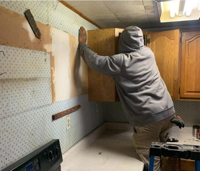 One of our SERVPRO technicians removing kitchen cabinets due to water damage.